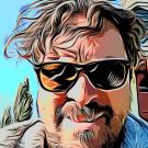 Psychedelic filtered selfie of a man with medium length brown hair wearing sunglasses.